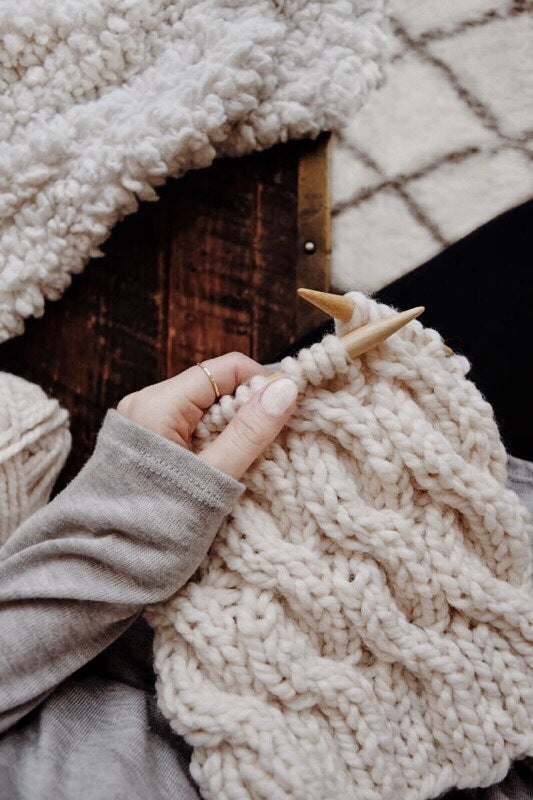 Side view of cable knit beanie pattern showing ribbed brim and cable design detail