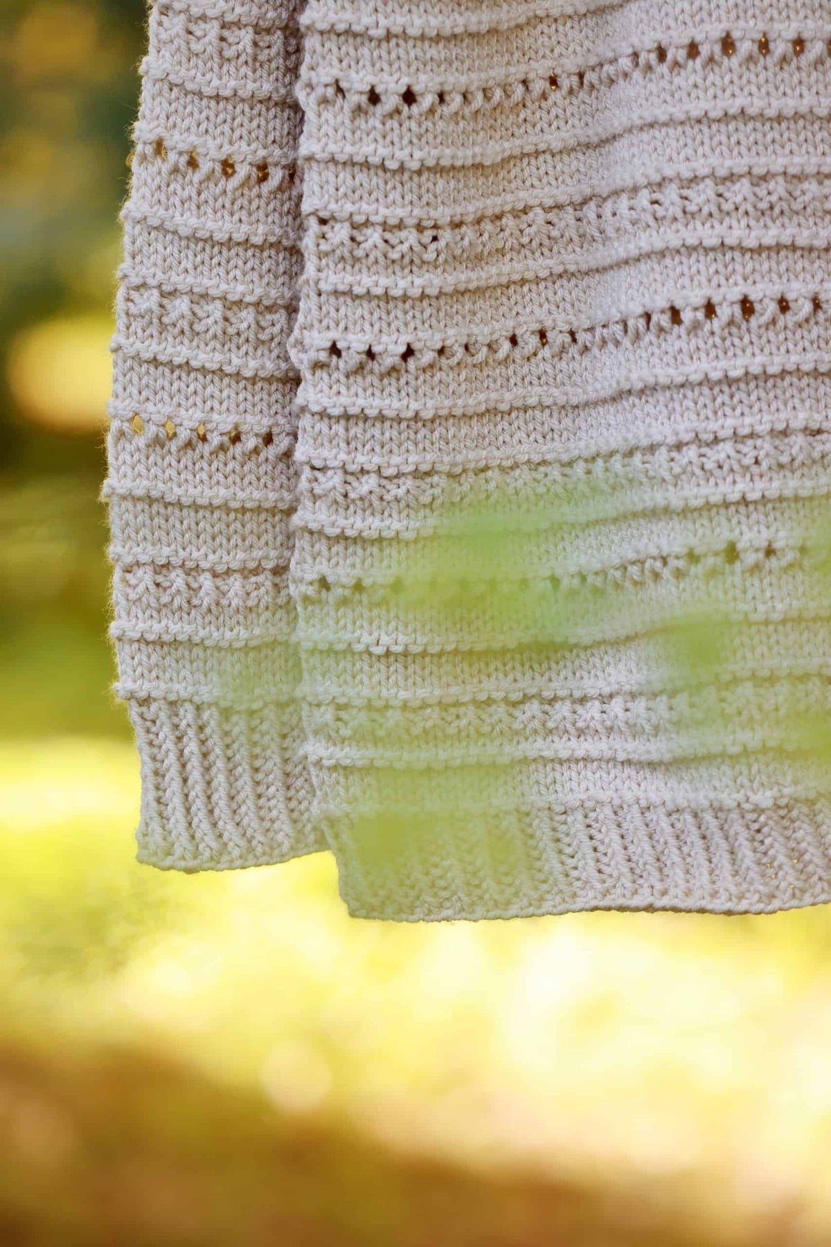 Woman modeling cream lace raglan sweater with textured eyelet details and ribbed cuffs