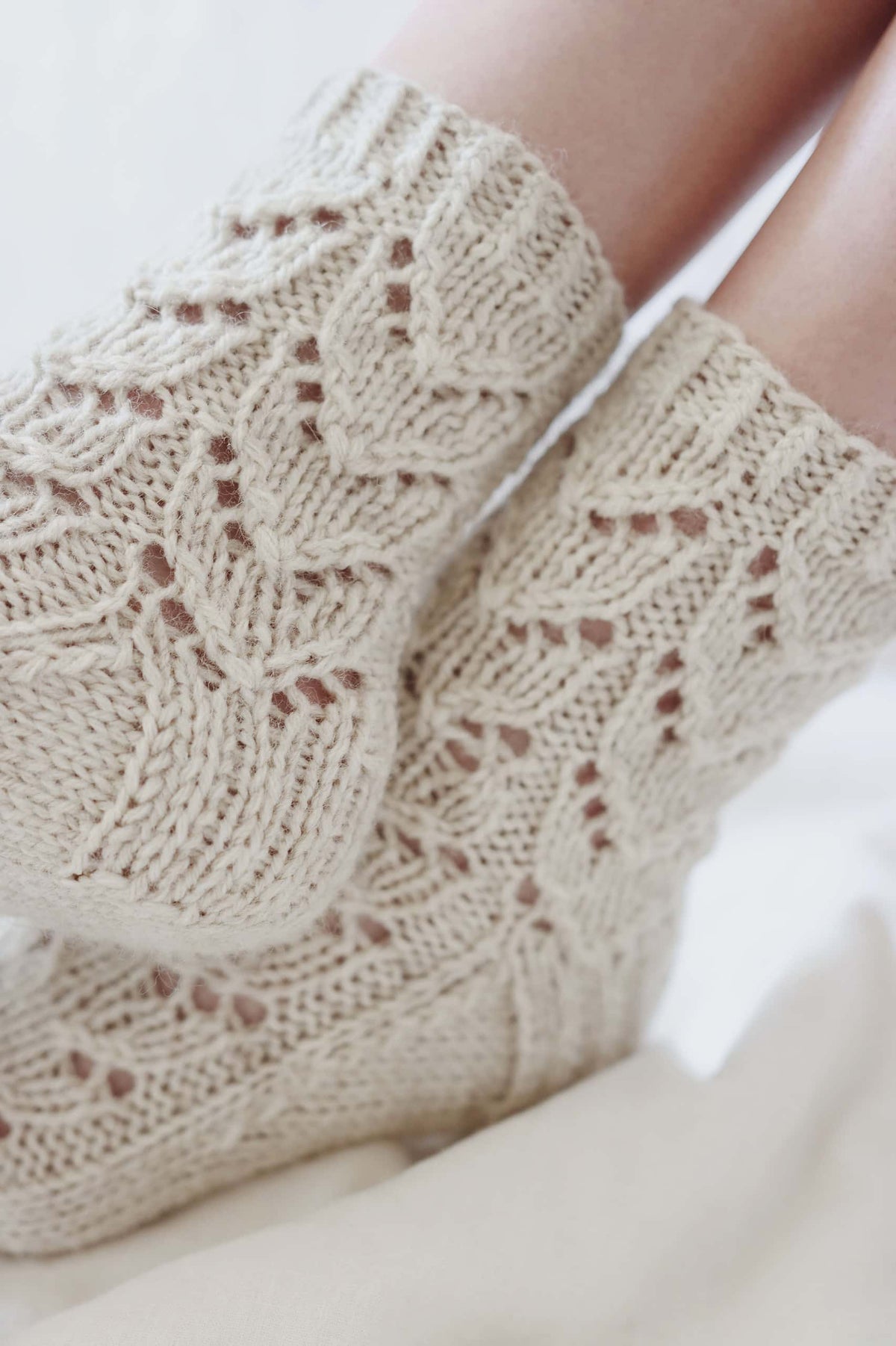Side view of Alpine lace socks knit in worsted weight yarn with beautiful stitch detail