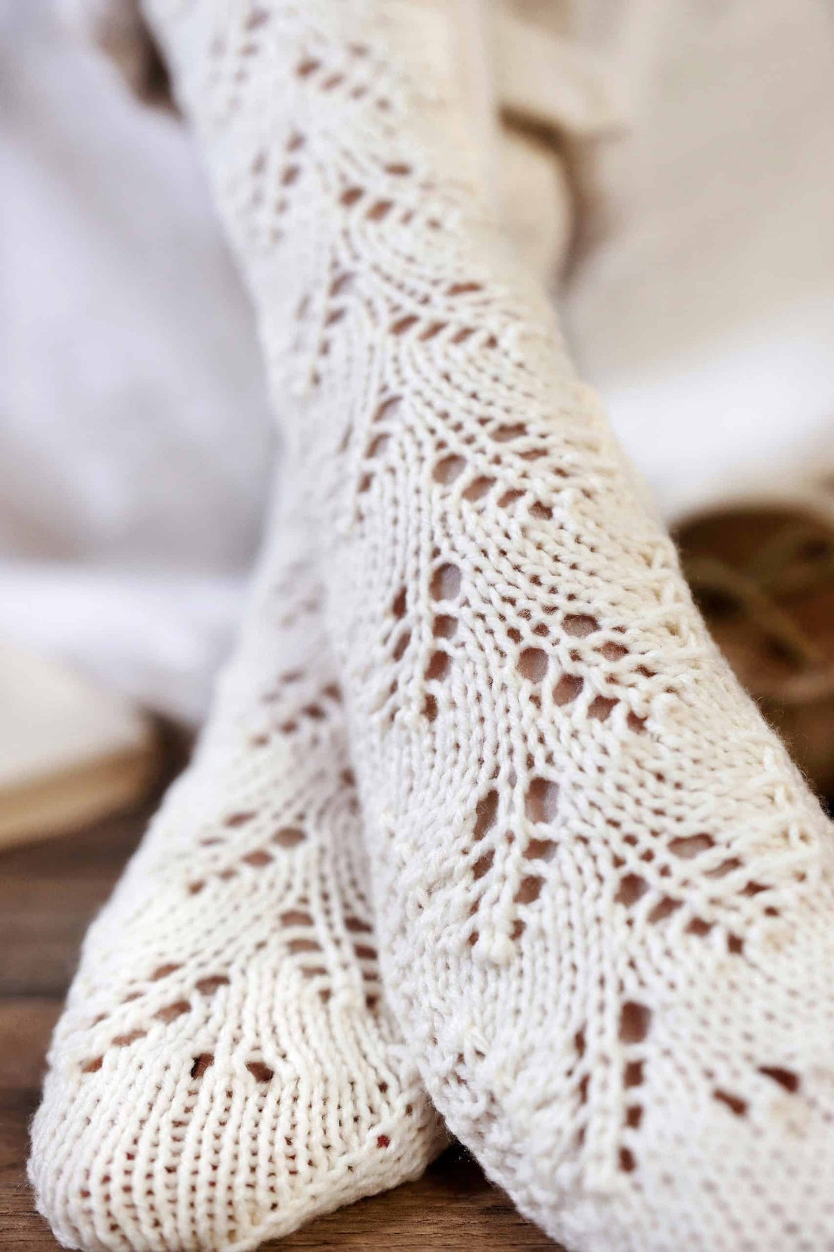 Close up of lace leaf detail on hand knit DK weight socks pattern