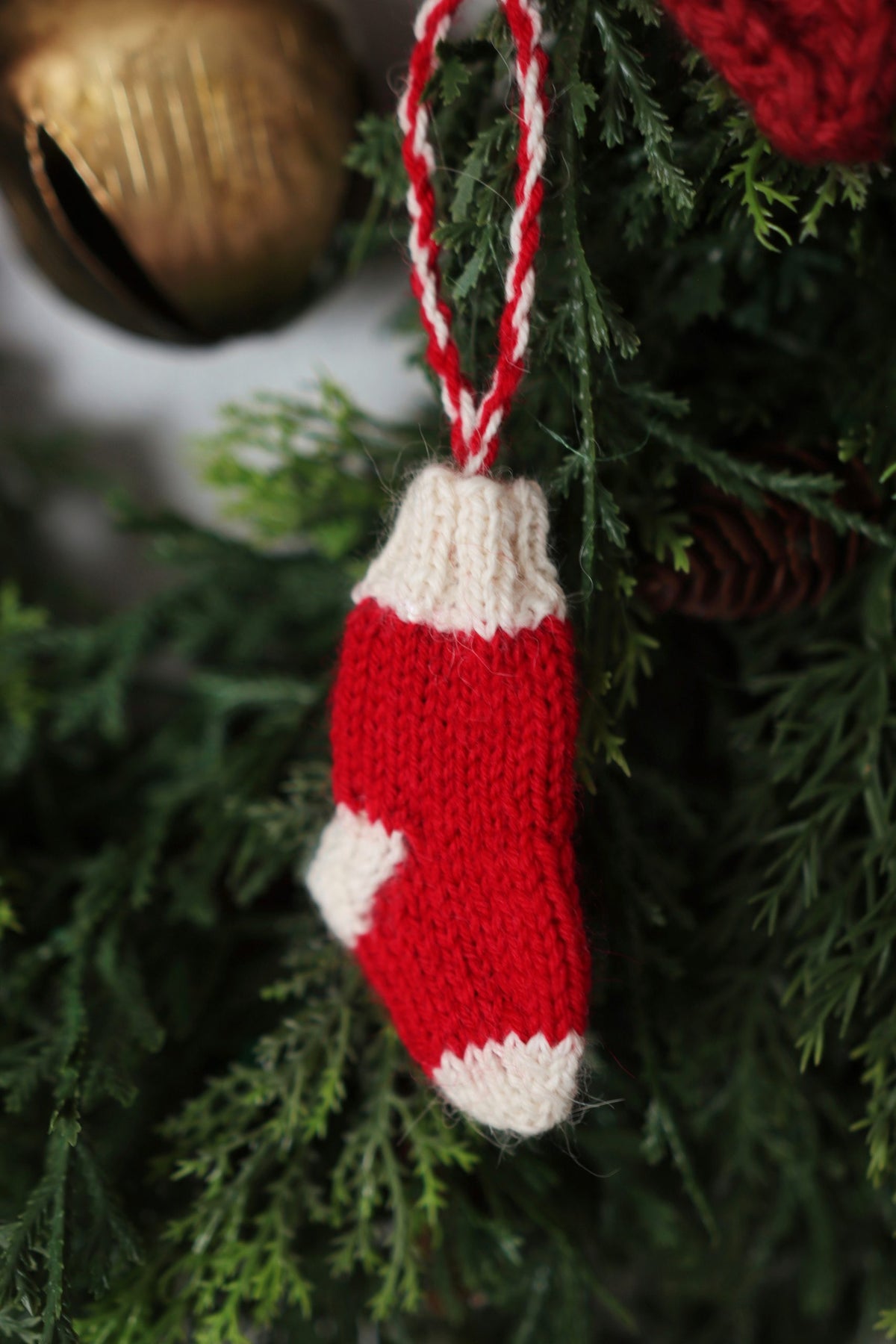 Christmas stocking ornament knitting pattern in neutral yarn with traditional holiday styling