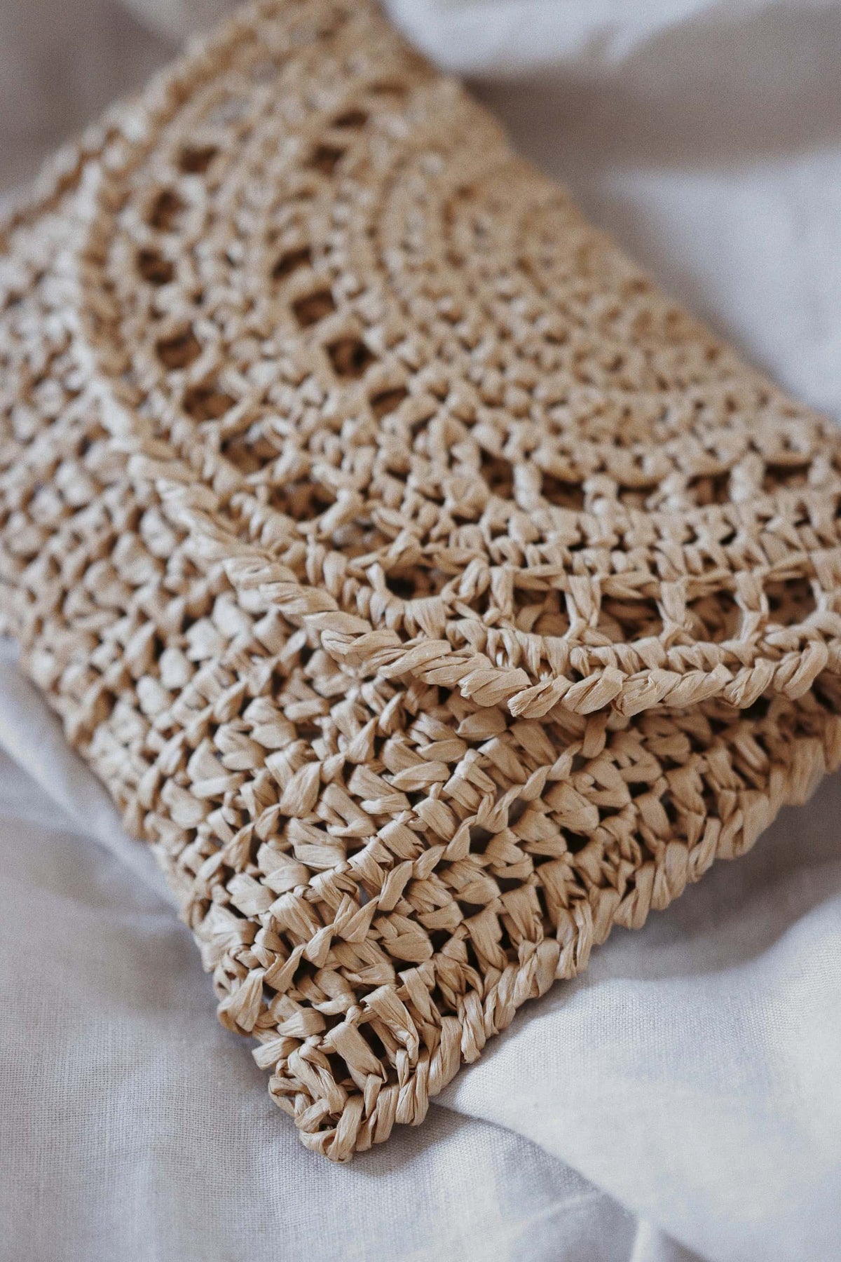 Handmade straw clutch bag from beginner-friendly crochet pattern