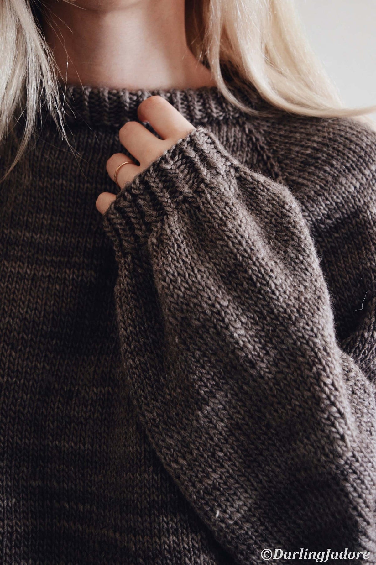 Woman wearing cream Posy raglan sweater knitting pattern with feminine keyhole back