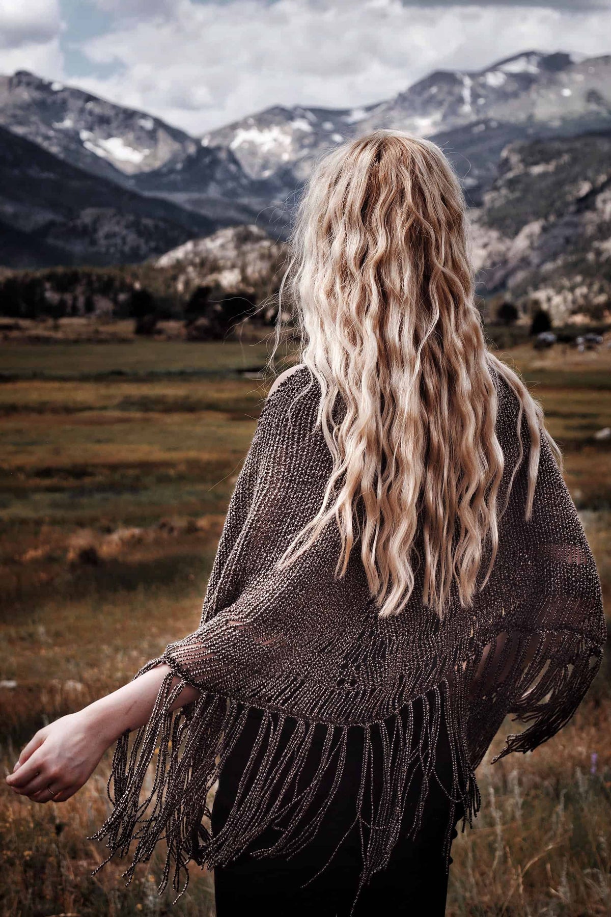 Woman wearing cream crescent shawl with tassels - easy beginner shawl knitting pattern