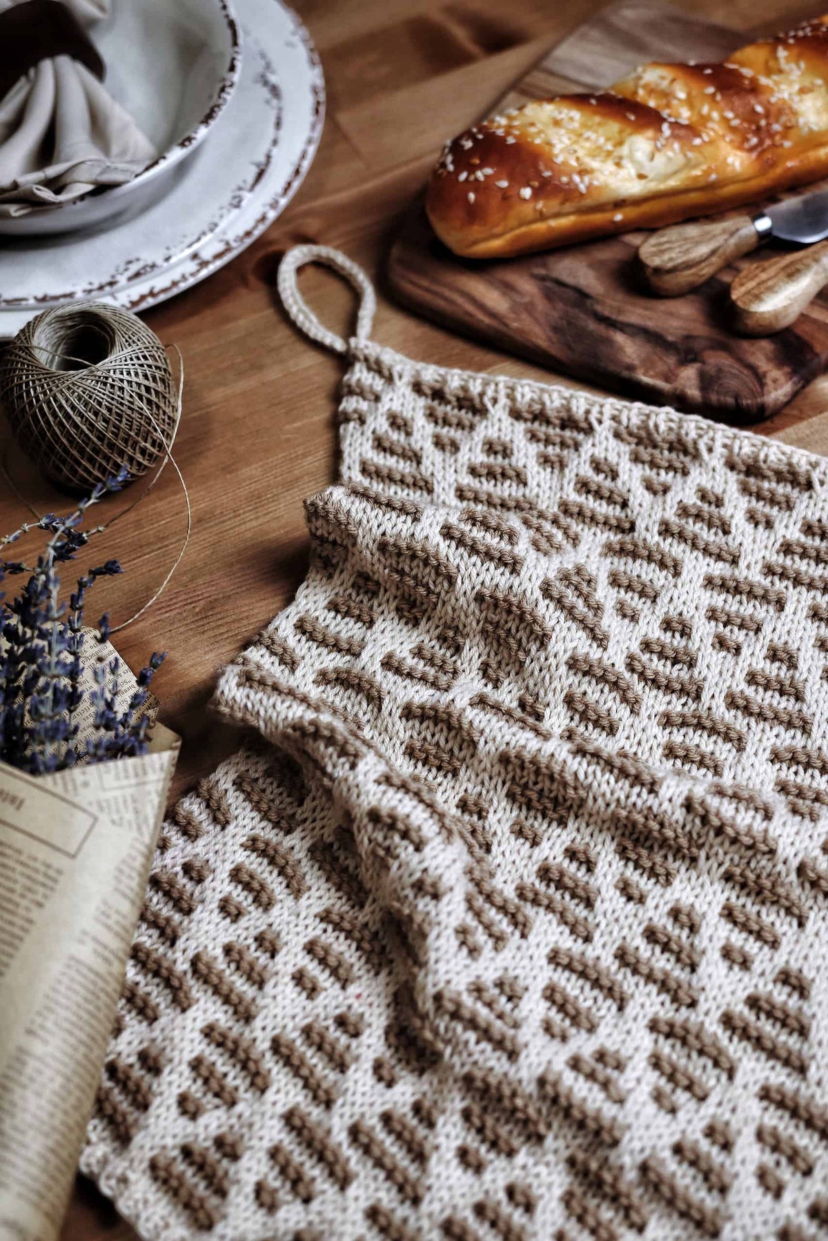Beginner-friendly tea towel knitting pattern with optical illusion chevron striping in kitchen setting
