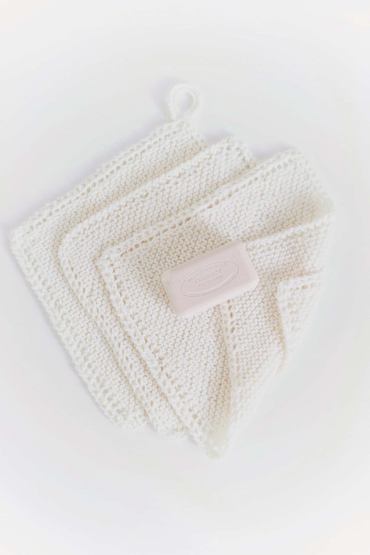 Close-up of bias garter stitch washcloth with delicate eyelet lace border - rustic home knitting pattern