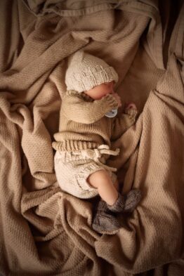 Adorable baby wearing soft hand-knit outfit