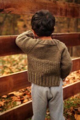 Child wearing cream raglan sweater knit in stockinette stitch - Sapling Sweater pattern by Darling Jadore